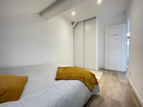 une chambre avec un lit avec une couverture jaune dessus dans l'établissement appartement entier sur Reims - 4 Voyageurs, à Reims