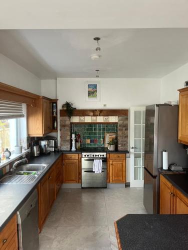 a kitchen with wooden cabinets and a stove top oven at The Bunga, Portrush in Portrush