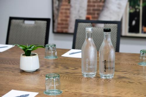 two bottles of water sitting on a wooden table at Mercure Sydney Blacktown in Blacktown