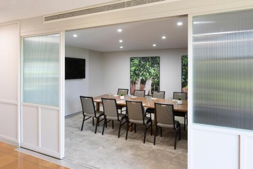 a dining room with a table and chairs at Mercure Sydney Blacktown in Blacktown
