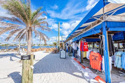 a beach with a palm tree and a blue building at North Lost Key Landing 2B in Pensacola