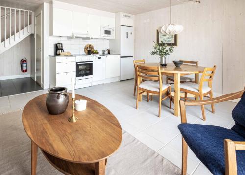 een keuken en een woonkamer met een tafel en stoelen bij Hönö Sjöbodar in Hönö