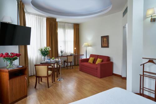 a living room with a red couch and a table at Hotel Cityzen Guayaquil in Guayaquil