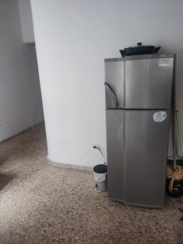 a silver refrigerator in a room with a wall at Apartamentos cerca ala basílica in Buga