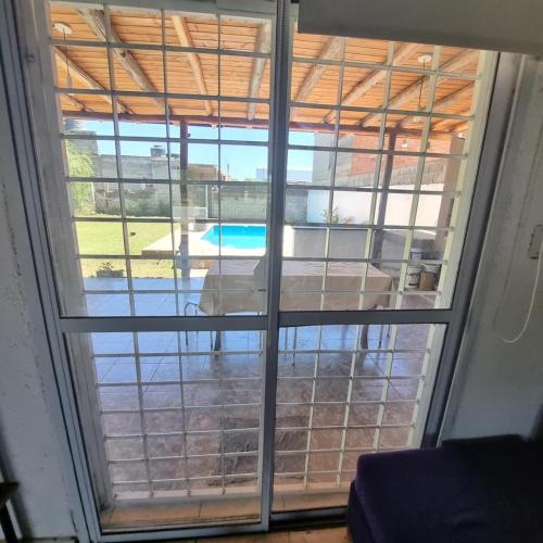 een raam met uitzicht op een zwembad. bij La normita in Villa Anizacate