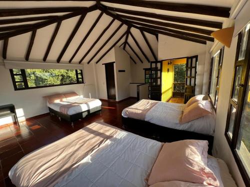 a bedroom with three beds in a room at CASA CAMPESTRE VILLA SANTANA in Villa de Leyva