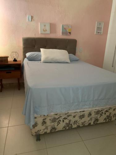 ein Schlafzimmer mit einem Bett mit einer blauen und weißen Decke in der Unterkunft Casinha da Paz in Aracaju