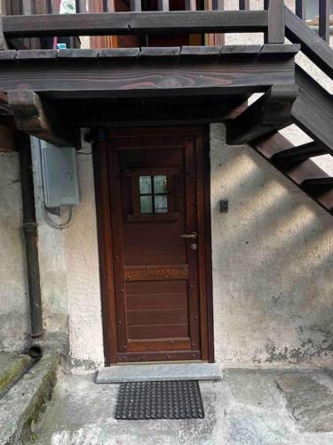 a wooden door on a building with a staircase at Una piccola bomboniera in Gaby