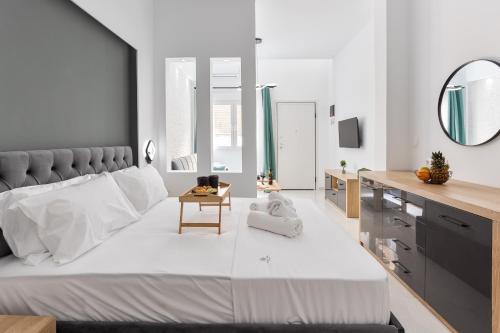 a bedroom with a large white bed and a mirror at New Luxury Apartment in Downtown in Thessaloniki