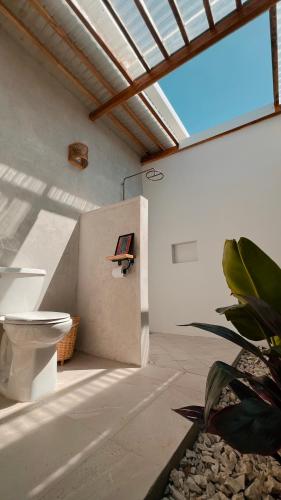 a bathroom with a toilet in a room with a window at Tukasa - Surfhouse Popoyo in Popoyo