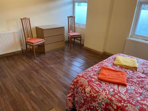 um quarto com uma cama, 2 cadeiras e uma cómoda em Fully equipped entire flat in Lewisham em Londres