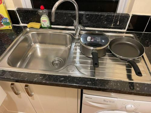 a kitchen sink with two pots and pans on it at Fully equipped entire flat in Lewisham in London