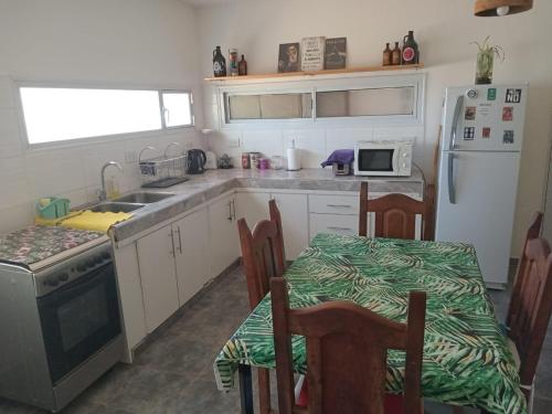 uma cozinha com um lavatório e uma mesa com cadeiras em La Casita de Nala em Neuquén