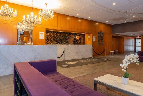 a lobby with a couch and a table and chandeliers at Sandman Signature Edmonton Downtown Hotel in Edmonton