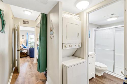 e bagno con servizi igienici bianchi e doccia. di The Breakers #220 Beach Condo, Beautiful Ocean View at Coligny Beach, 4 N Forest Beach Drive Hilton Head, Walk to all Shops Restaurants, Renovated Jan 2024, Vacation Rental HHI LLC a Hilton Head Island