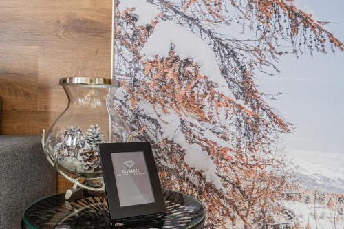 a table with a glass vase and a sign on it at Diamante ampio monolocale stile chalet alpino in Passo del Tonale