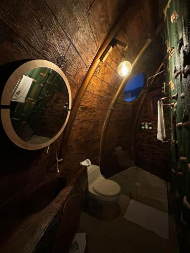 a small bathroom with a toilet and a mirror at Eco glamping Santillana in Charalá