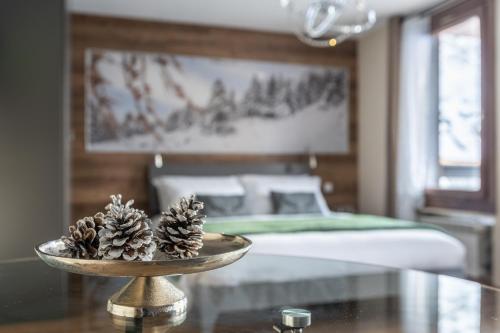 two pine cones on a table in a bedroom at Diamante ampio monolocale stile chalet alpino in Passo del Tonale