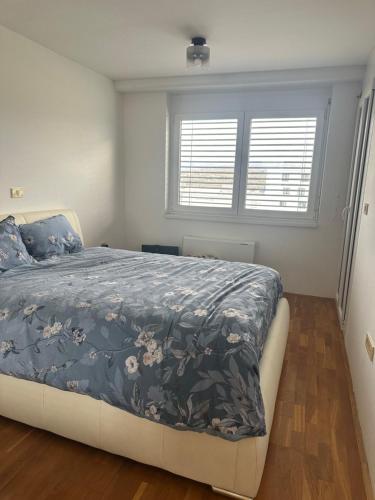 1 Schlafzimmer mit einem Bett mit blauer Decke und 2 Fenstern in der Unterkunft Morski užitek “sea delight” in Koper