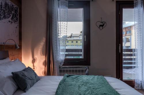 a bedroom with a bed and a window at Diamante ampio monolocale stile chalet alpino in Passo del Tonale