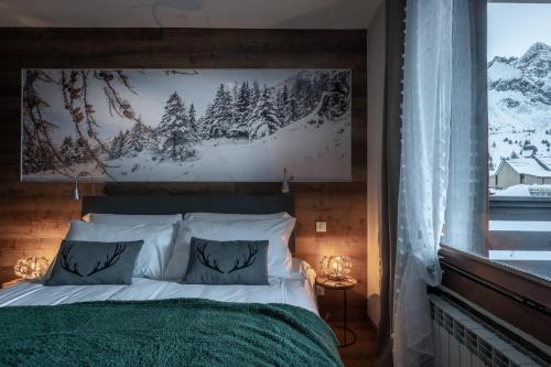 a bedroom with a bed and a large window at Diamante ampio monolocale stile chalet alpino in Passo del Tonale