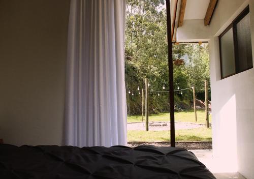 基多的住宿－Cabaña en la montaña Ilalo - Quito，一间卧室设有一张床和一个大窗户