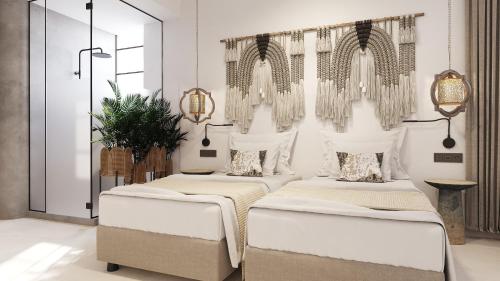 Megálon ChoríonにあるUtopia Luxury Resortの白い壁の客室内のベッド2台