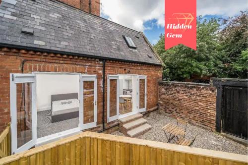 a brick house with large windows and a fence at Perfect for Professionals in LS1 & LGI - Private Garden! Contact us for Better Offers! in Leeds