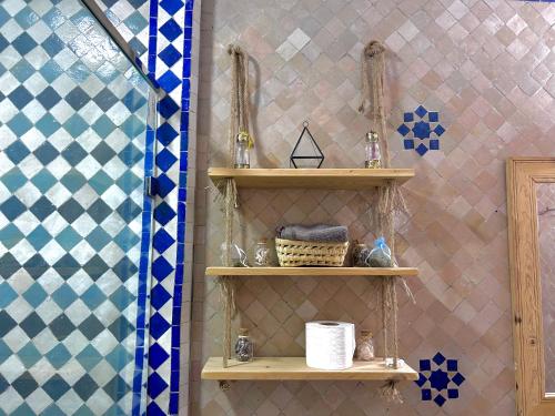 ein Badezimmer mit Holzregalen und einer Dusche in der Unterkunft Riad Noor Medina in Fès