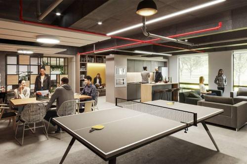 a ping pong table in a room with people sitting at tables at Hermoso Loft en North Point in Bogotá