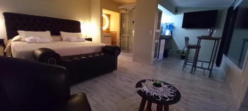 a bedroom with a bed and a couch and a table at AYRES SUITE in Villa Carlos Paz