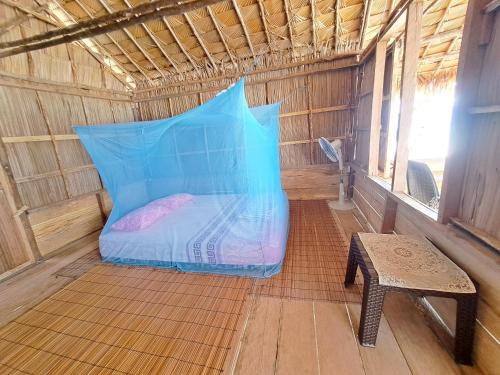 a bed in a small room with a bench in it at Raja Ampat Jousuba Homestay in Minyaifuin
