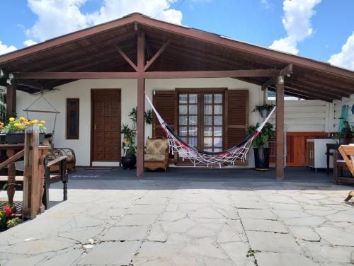 a pavilion with a hammock on a patio at CASA DA FAMÍLIA DE GRAMADO in Gramado