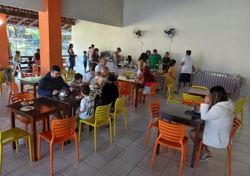 um grupo de pessoas sentadas em mesas em um restaurante em Acquamarine Park Hotel em Guarapari