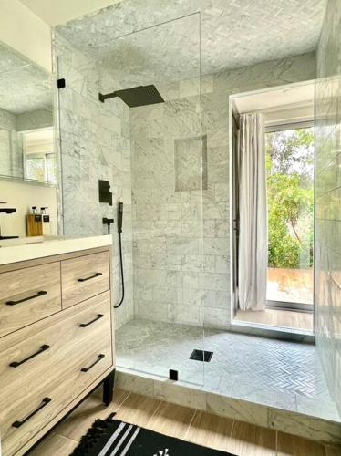 a bathroom with a shower with a glass door at The Glass House Montecito in Santa Barbara
