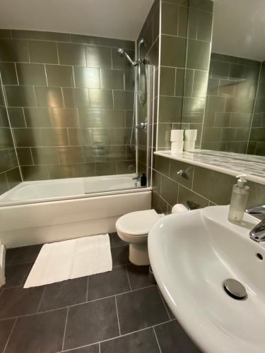 y baño con lavabo, aseo y bañera. en Stylish City Centre Apartment by Cloud Suites, en Mánchester