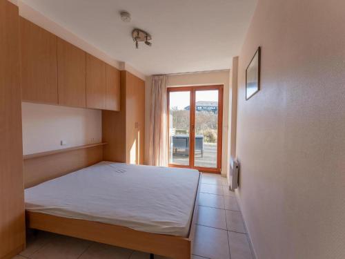 a small bedroom with a bed and a window at Plaza A1A02 located on the dunes in Oostduinkerke