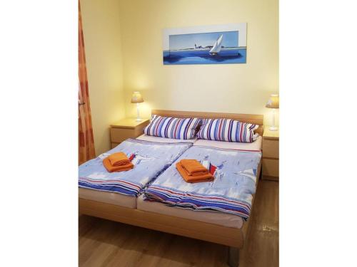 ein Schlafzimmer mit einem Bett mit zwei orangenen Handtüchern darauf in der Unterkunft Beach dune 12 on the beach in Ostseebad Karlshagen