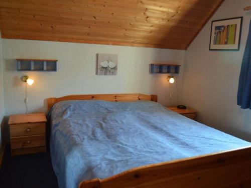 1 dormitorio con 1 cama de madera y 2 mesitas de noche en Holiday home Angel 2, en Warin