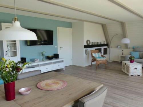 a living room with a table and a living room with a couch at Holiday home Sehnsucht Schlei in Brodersby