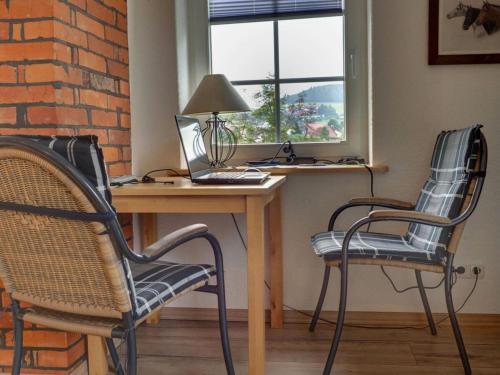 Duas cadeiras e uma secretária com um computador portátil. em Holiday apartment loft em Hehlen