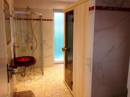 a bathroom with a shower and a red stool at Aquarius on the swimming lake in Aurich