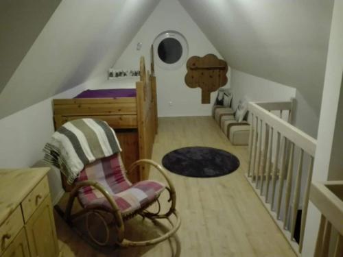 a attic room with a bed and a rocking chair at Aquarius on the swimming lake in Aurich