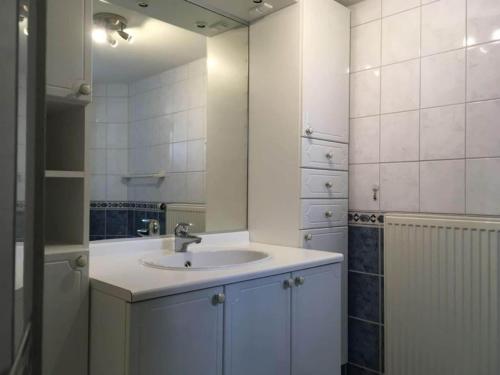 a white bathroom with a sink and a mirror at Holiday home Seestern 283 in De Zandloper