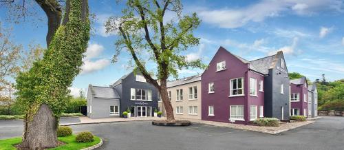 a row of houses in a street with a tree at Wilton Hotel Bray in Bray