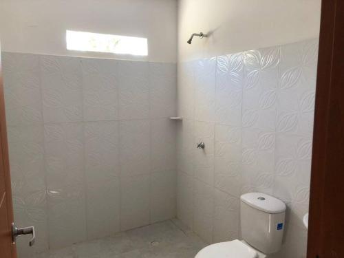 een witte badkamer met een toilet en een raam bij Cabaña en Santiago de Tolú. in San Silvestre