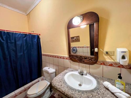 a bathroom with a sink and a toilet and a mirror at Hotel Caxa Real in Comayagua