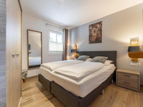 a bedroom with a large bed and a mirror at Luxury Tauern Suite Walchen Kaprun 5 in Piesendorf