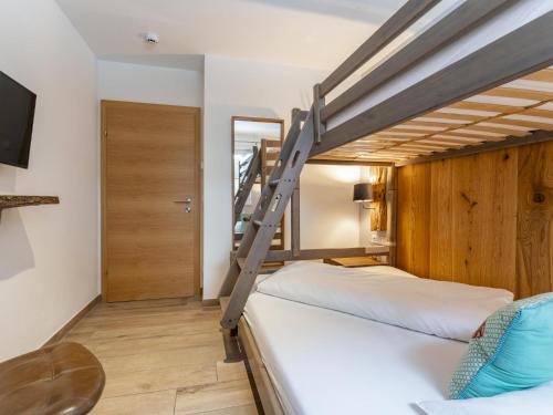 a bedroom with two bunk beds and a tv at Luxury Tauern Suite Walchen Kaprun 5 in Piesendorf