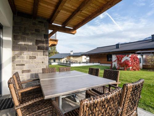 a wooden table and chairs on a patio at Luxury Tauern Suite Walchen Kaprun 5 in Piesendorf